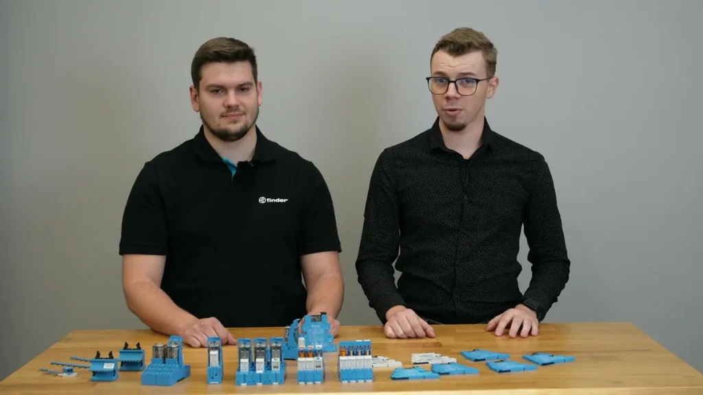 Szymon z ControlByte i Jakub z Finder Polska przy stole z przekaźnikami interfejsowymi